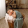 Maé a rejoint le concours — aidez-le/la à gagner de superbes lots ! baby, newborn, sleeping, infant, swaddled, basket, wooden_bucket, blanket, fringe, soft_texture, portrait, cozy, interior, curtain, floral_background, vintage_door, rug, studio_photography, peaceful, cute