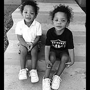 Ez. Ih. is registered to the contest to win money with this photo: black_and_white, casual_clothing, children, concrete, curly_hair, front_door, front_porch, happy, monochrome, outdoor, pair, portrait, siblings, sitting, smiling, sneakers, steps, toddler, two_children, young_kids