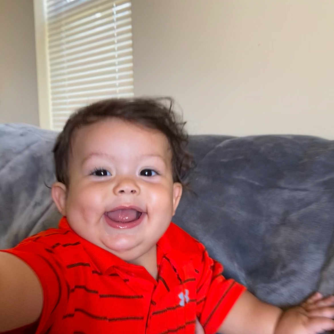 Jamin is registered to the contest to win money with this photo: architecture, baby, babylaughing, bodypart, clothing, couch, face, finger, furniture, hand, happy, head, homedecor, indoors, laughing, person, photography, portrait, smile, t_shirt