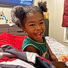 Ace joined the competition — help win amazing prizes! child, toddler, smiling, laughing, portrait, indoor, bedroom, bed, blanket, bedding, curly_hair, hair_buns, green_shirt, sitting, happy, joyful, bottle, dresser, television, home