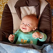 Maël a rejoint le concours — aidez-le/la à gagner de superbes lots ! baby, infant, smiling, green_onesie, blanket, baby_seat, face, happy, child, tiled_floor, cozy, indoors, cushion, clothing, person, portrait, cute, newborn, baby_boy, soft