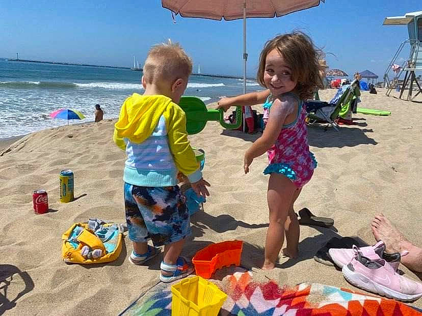 Kyra joined the competition — help win amazing prizes! beach, body_of_water, child, fun, joy, leisure, natural_environment, people, people_on_beach, person, photograph, public_space, recreation, sand, shade, shorts, sky, snapshot, summer, toddler