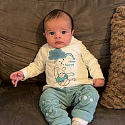 Silas participe au concours pour gagner de l'argent avec cette photo : baby, blue_pants, child, clothing, couch, cute, expression, face, indoor, infant, person, pillow, portrait, sitting, smiling_face_design, socks, sofa, texture, wall, white_shirt