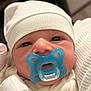 baby, pacifier, hat, close_up, infant, cute, face, newborn, white_clothing, soft, skin, child, sleepwear, indoors, young, headwear, expressionless, comfort, warm, portrait