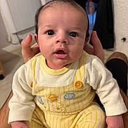 Silas a rejoint le concours — aidez-le/la à gagner de superbes lots ! baby, infant, child, person, clothing, yellow, onesie, hands, indoor, portrait, cute, face, eyes, sitting, expression, human, young, warm, cozy, skin