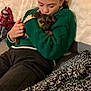Neva participe au concours pour gagner de l'argent avec cette photo : affection, animal, black_pants, blanket, casual_clothing, comfort, couch, cozy, cuddling, dog, doll, green_sweater, home, indoor, leisure, person, pet, relaxing, resting, young_person