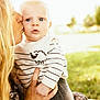 baby, woman, kiss, outdoor, sunlight, blonde_hair, striped_sweater, sheep_design, holding, portrait, grass, nature, affection, love, child, cute, face, person, warmth, family