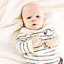 baby, infant, child, face, blue_eyes, sweater, striped_clothing, sheep_design, blanket, soft_texture, cozy, lying_down, cute, portrait, young_child, indoor, comfortable, skin, expression, small_hands