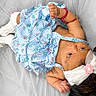 Serena joined the competition — help win amazing prizes! baby, infant, child, dress, headband, flower, socks, lying_down, soft_surface, curious, cute, skin, hand, footwear, fabric, pattern, pink, blue, white, portrait