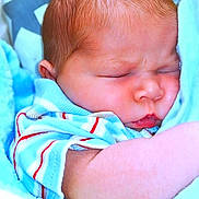 Winston is registered to the contest to win money with this photo: baby, sleeping, infant, blue_blanket, star_pattern, striped_clothing, closeup, peaceful, soft_texture, newborn, cute, face, arm, skin, portrait, cozy, child, resting, indoors, warm