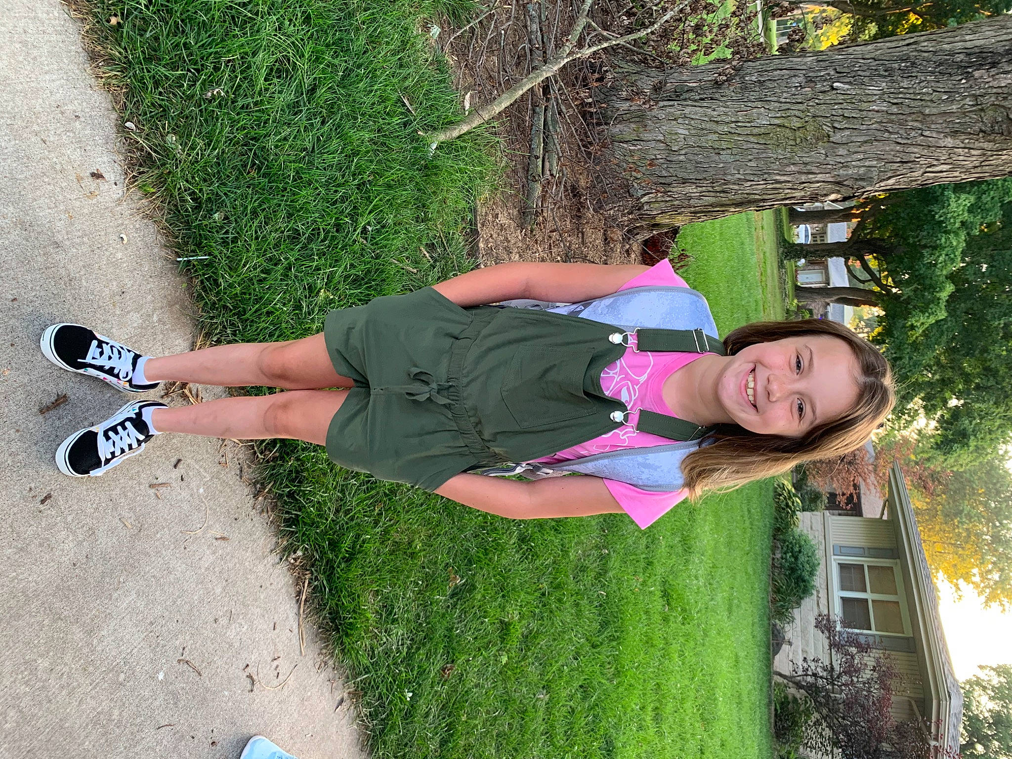 Erin is registered to the contest to win money with this photo: asphalt, fun, grass, happy, human_leg, joy, knee, leisure, people_in_nature, person, plant, shadow, shrub, smile, summer, t_shirt, thigh, tree, walking_shoe, yellow