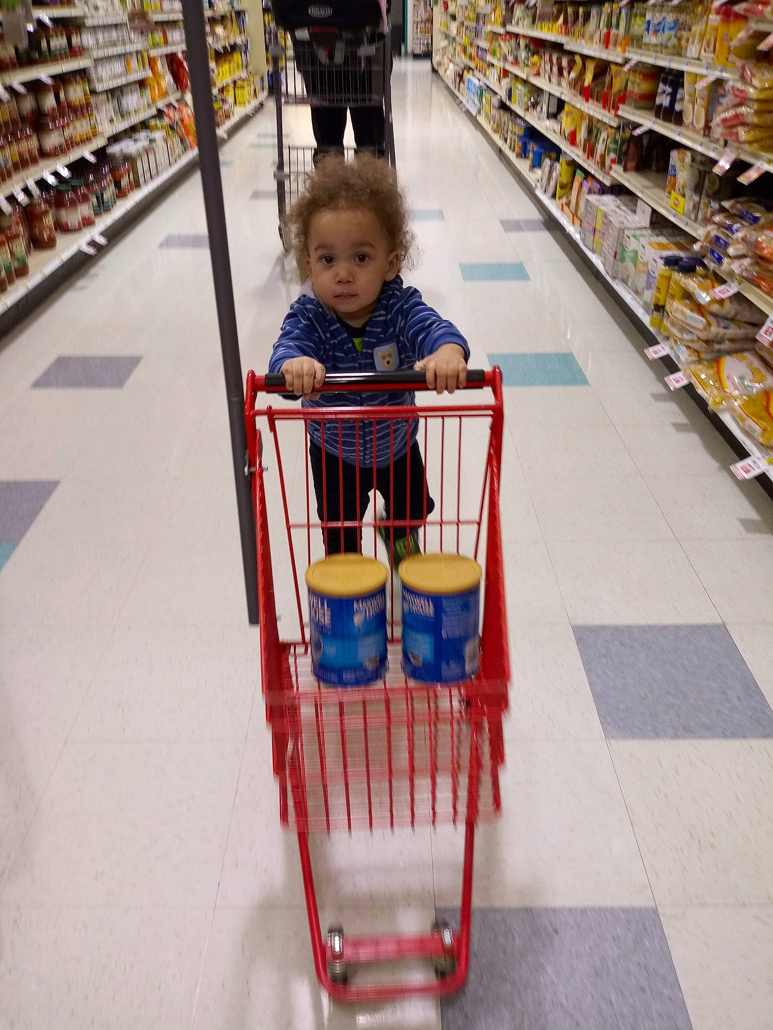 Isaiah is registered to the contest to win money with this photo: aisle, cart, child, grocery_store, person, retail, service, shopping, shopping_cart, supermarket, toddler, vehicle