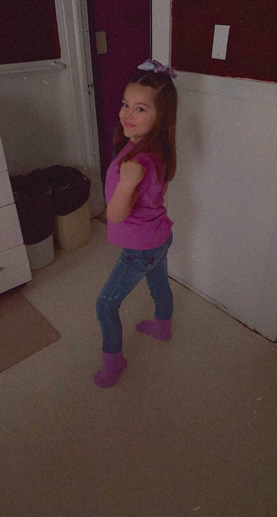 Maddison is registered to the contest to win money with this photo: floor, flooring, fun, hardwood, human_leg, jeans, joy, knee, leg, long_hair, magenta, person, pink, purple, shoulder, sportswear, t_shirt, thigh, toddler, trunk