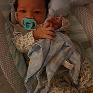 Milo joined the competition — help win amazing prizes! baby, pacifier, blanket, plush_toy, pajamas, baby_seat, infant, cute, soft_toy, cushion, sleepwear, child, indoors, footwear, animal_print, comfort, resting, baby_clothes, small_hands, warm_lighting