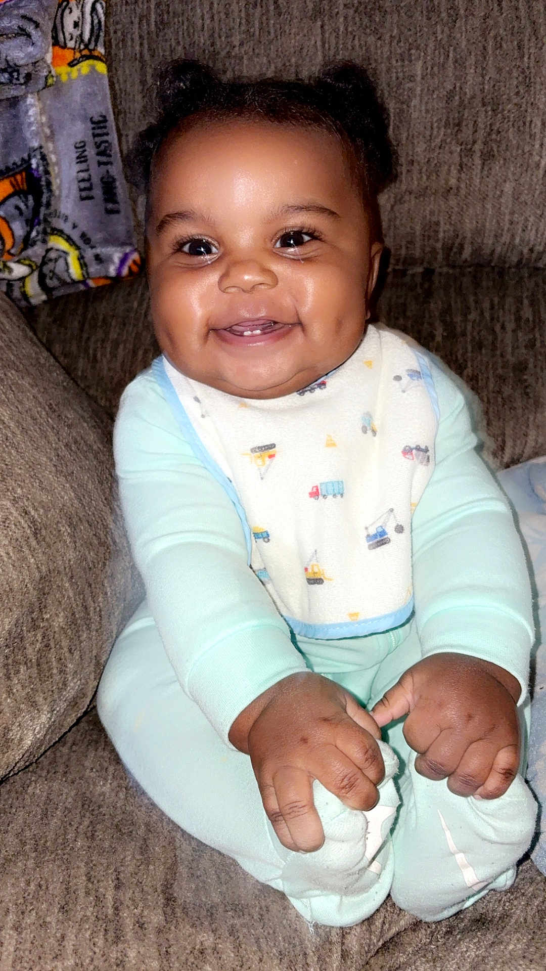 Kenyan joined the competition — help win amazing prizes! baby, bib, blanket, bright_eyes, chubby_cheeks, closeup, couch, cozy, dimple, feet, hands, infant, living_room, onesie, patterned_fabric, portrait, sitting, smiling, teeth, toes