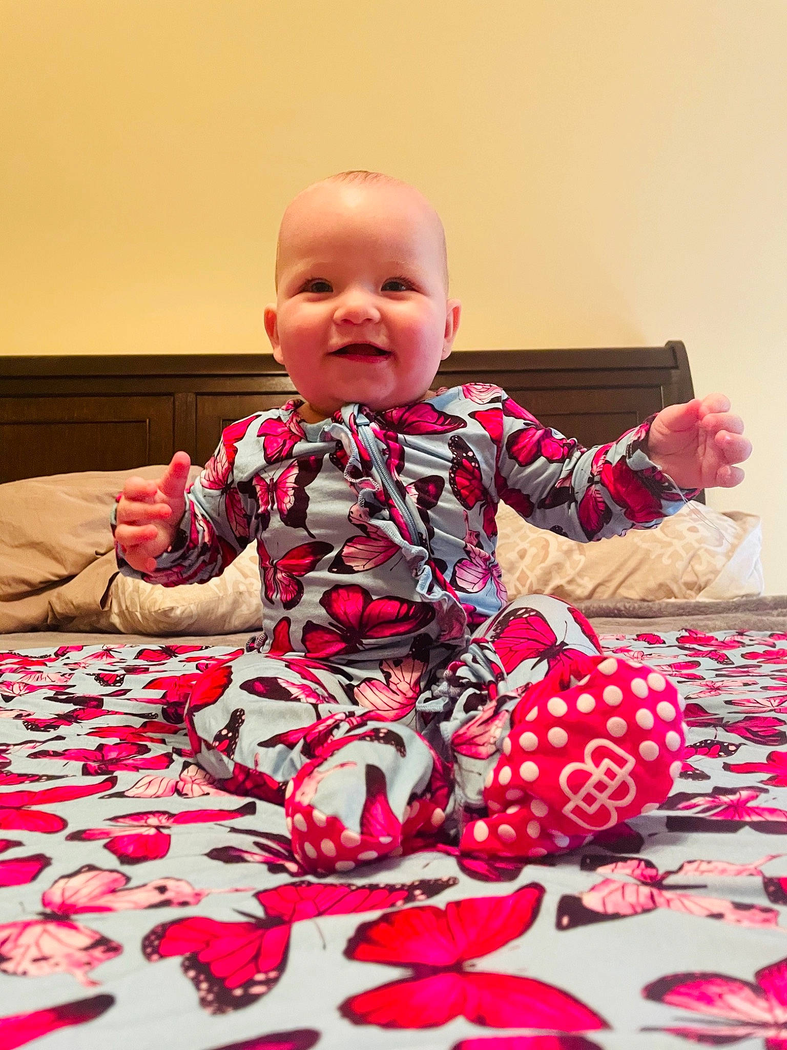 Alaska is registered to the contest to win money with this photo: arm, baby, baby_toddler_clothing, comfort, dress, flooring, fun, happy, head, leg, magenta, pattern, person, pink, purple, red, sleeve, smile, t_shirt, textile