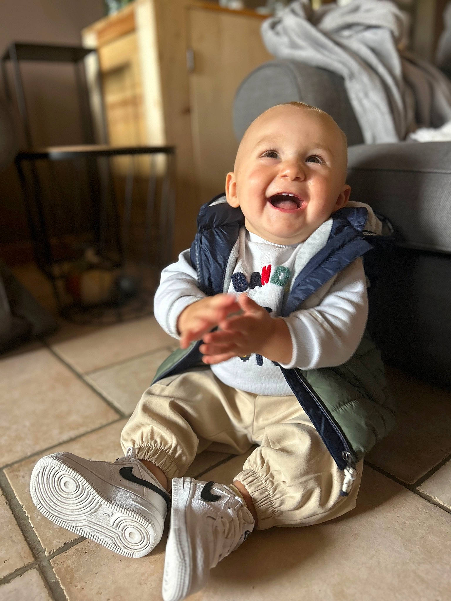 Maoh participe au concours pour gagner de l'argent avec cette photo : baby, baby_laughing, baby_toddler_clothing, chair, child, collar, comfort, flooring, fun, happy, hat, human_leg, person, room, sitting, sleeve, smile, sneakers, suit, toddler
