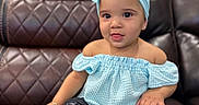 Emily joined the competition — help win amazing prizes! baby, blue_clothing, bow, child, couch, cute, face, happy, headband, indoor, leather_couch, off_shoulder_top, pants, person, portrait, shoes, sitting, smiling, toddler, young_child