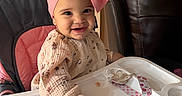 Emily joined the competition — help win amazing prizes! baby, bow_headband, child, couch, cute, earrings, hand, happy, highchair, infant, leather_sofa, living_room, long_sleeve, pacifier_clip, patterned_clothing, pink, portrait, smiling, staircase, tray_table