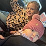 child, baby, car, hat, pink_hat, leopard_print, sweater, smiling, curious, seat, sunlight, window, vehicle_interior, portrait, happy, casual_clothing, cute, pom_pom, blond_hair, face