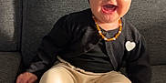 Valentina participe au concours pour gagner de l'argent avec cette photo : baby, child, smiling, laughing, sitting, black_cardigan, headband, bow, leopard_print_socks, cream_pants, couch, gray_couch, indoor, happy, cute, jewelry, necklace, heart_patch, shadow, sunlight