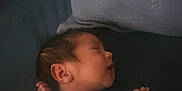 Luke is registered to the contest to win money with this photo: newborn, baby, sleeping, blue_onesie, monkey_pattern, infant, peaceful, resting, pillow, bed, child, person, portrait, cute, small, skin, hair, hand, face, indoors