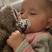 Romy a rejoint le concours — aidez-le/la à gagner de superbes lots ! baby, pacifier, blanket, indoor, cozy, cute, sleepy, child, infant, fuzzy, hand, clothing, face, pacifier_panda, pink, gray, heart_doodle, portrait, soft_light, peaceful