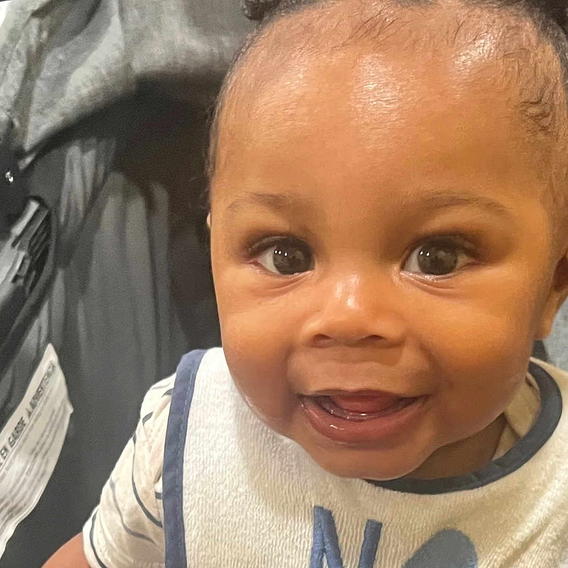 Omri joined the competition — help win amazing prizes! baby, bib, child, closeup, clothing, cute, eyes, face, happy, head, indoor, infant, person, portrait, seat, skin, smiling, stroller, tongue, young