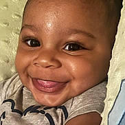 Omri is registered to the contest to win money with this photo: baby, smile, face, close_up, infant, happy, tongue_out, cute, child, skin, eyes, clothing, blanket, portrait, indoors, joy, expression, person, head, baby_girl