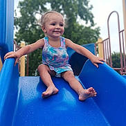 Gracelynn joined the competition — help win amazing prizes! barefoot, blue_slide, casual, child, clothing, daylight, fun, happy, outdoor, park, person, play, playground, recreation, slide, smile, summer, toddler, tree, young_child