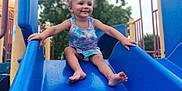 Gracelynn joined the competition — help win amazing prizes! barefoot, blue_slide, casual, child, clothing, daylight, fun, happy, outdoor, park, person, play, playground, recreation, slide, smile, summer, toddler, tree, young_child