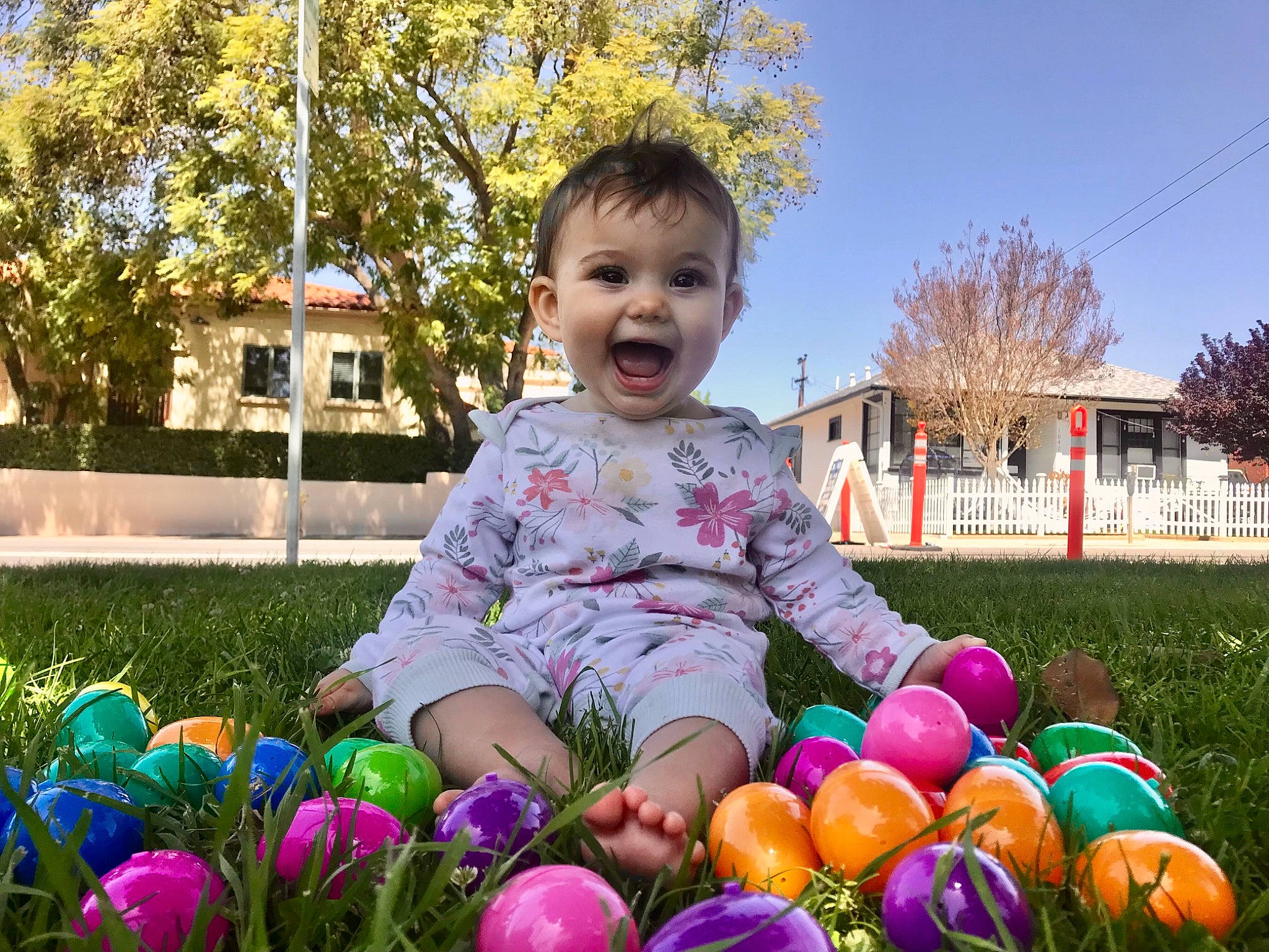 Sydney is registered to the contest to win money with this photo: baby_toddler_clothing, dress, eye, face, facial_expression, fun, grass, happy, jeans, leaf, leg, people_in_nature, person, photograph, pink, plant, sky, smile, tree, vertebrate
