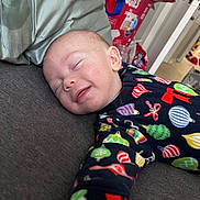 Austin joined the competition — help win amazing prizes! baby, background, child, clothing, comfort, couch, cozy, face, furniture, home, indoors, infant, nap, pajamas, person, pillow, relaxing, sleeping, smile, toddler