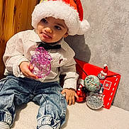 Liam participe au concours pour gagner de l'argent avec cette photo : bow_tie, carpet, child, christmas, cute, decorations, festive, holiday, holiday_spirit, indoor, jeans, ornament, playful, red_envelope, santa_hat, smiling, soft_lighting, striped_socks, toddler, white_shirt