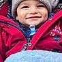 baby, child, smiling, hat, red_jacket, blue_blanket, pacifier, closeup, cozy, warm_clothing, infant, portrait, cute, happy, outdoor, winter_wear, knitted_hat, bundle, baby_face, soft_texture