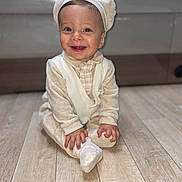 Cayden a rejoint le concours — aidez-le/la à gagner de superbes lots ! baby, child, smile, pajamas, cap, floor, wooden_floor, indoors, sitting, happy, cute, infant, portrait, hands, feet, cozy, clothing, person, young_child, candid