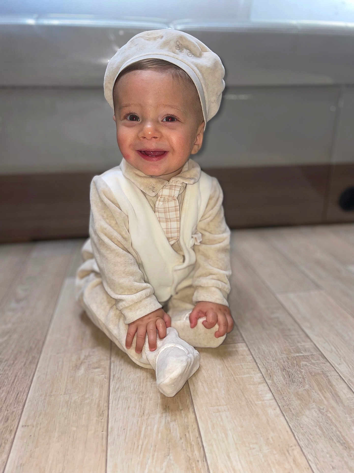 Cayden a rejoint le concours — aidez-le/la à gagner de superbes lots ! baby, child, smile, pajamas, cap, floor, wooden_floor, indoors, sitting, happy, cute, infant, portrait, hands, feet, cozy, clothing, person, young_child, candid