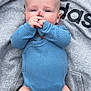 Kole is registered to the contest to win money with this photo: baby, infant, blue_onesie, grey_hoodie, adidas, chubby_legs, hand_near_mouth, curious_eyes, soft_skin, casual_clothing, laying_down, outdoor, cute, child, portrait, closeup, person, small_hands, baby_fashion, relaxed