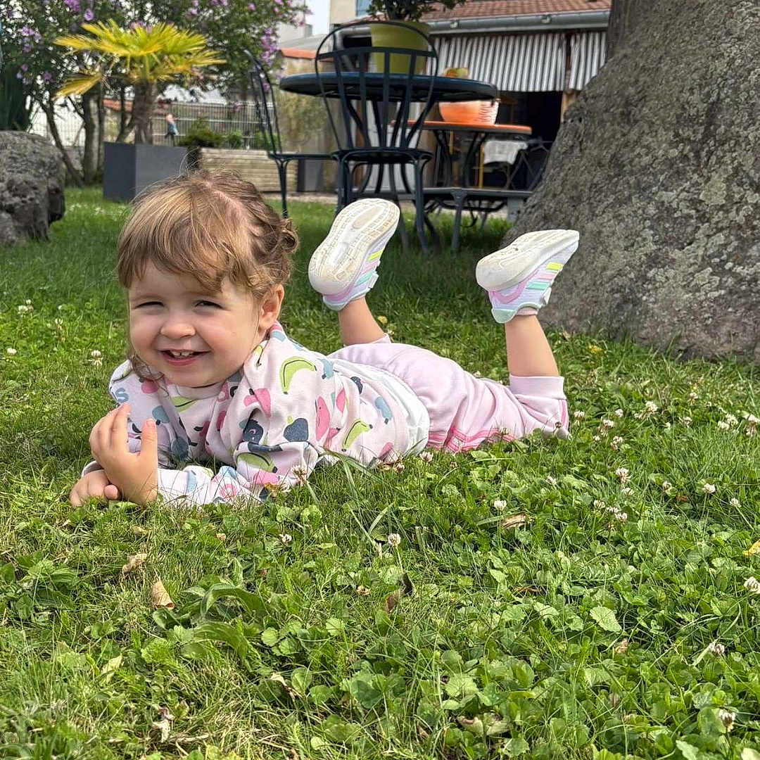Kélya a rejoint le concours — aidez-le/la à gagner de superbes lots ! building, chair, child, daylight, flower, garden, grass, happy, nature, outdoor, pants, plant, playful, rock, shoes, smile, sweatshirt, table, toddler, tree