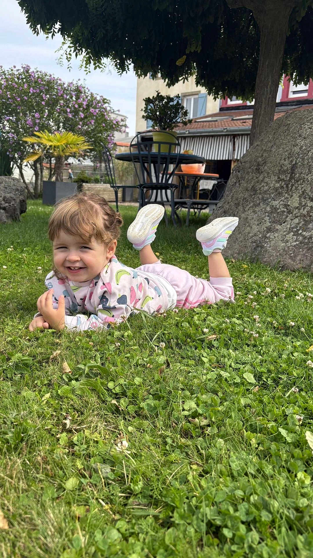 Kélya a rejoint le concours — aidez-le/la à gagner de superbes lots ! toddler, child, grass, outdoor, smile, tree, rock, flower, plant, table, chair, building, shoes, sweatshirt, pants, daylight, nature, happy, playful, garden