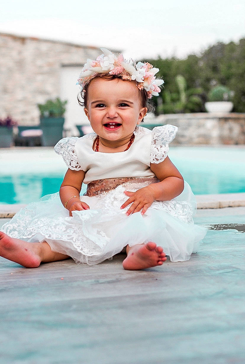 Kiara a rejoint le concours — aidez-le/la à gagner de superbes lots ! baby, baby_toddler_clothing, bridal_accessory, child, dress, embellishment, event, flash_photography, fun, grass, happy, headgear, headpiece, leisure, person, pink, recreation, skin, smile, toddler