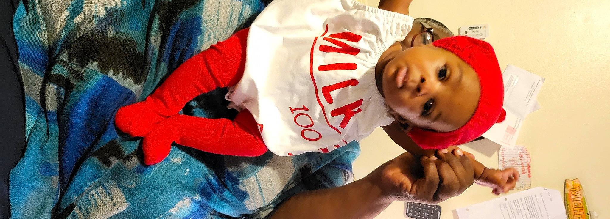 Kassidy is registered to the contest to win money with this photo: abdomen, baby, cap, carmine, child, comfort, computer_keyboard, elbow, finger, fun, hand, happy, hat, mouth, person, red, sleeve, smile, t_shirt, thigh