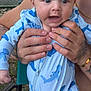 Grayson is registered to the contest to win money with this photo: baby, child, infant, onesie, shark_pattern, blue_clothing, hands, tattoos, outdoor, fence, grass, chair, person, portrait, expression, closeup, skin, face, holding, young