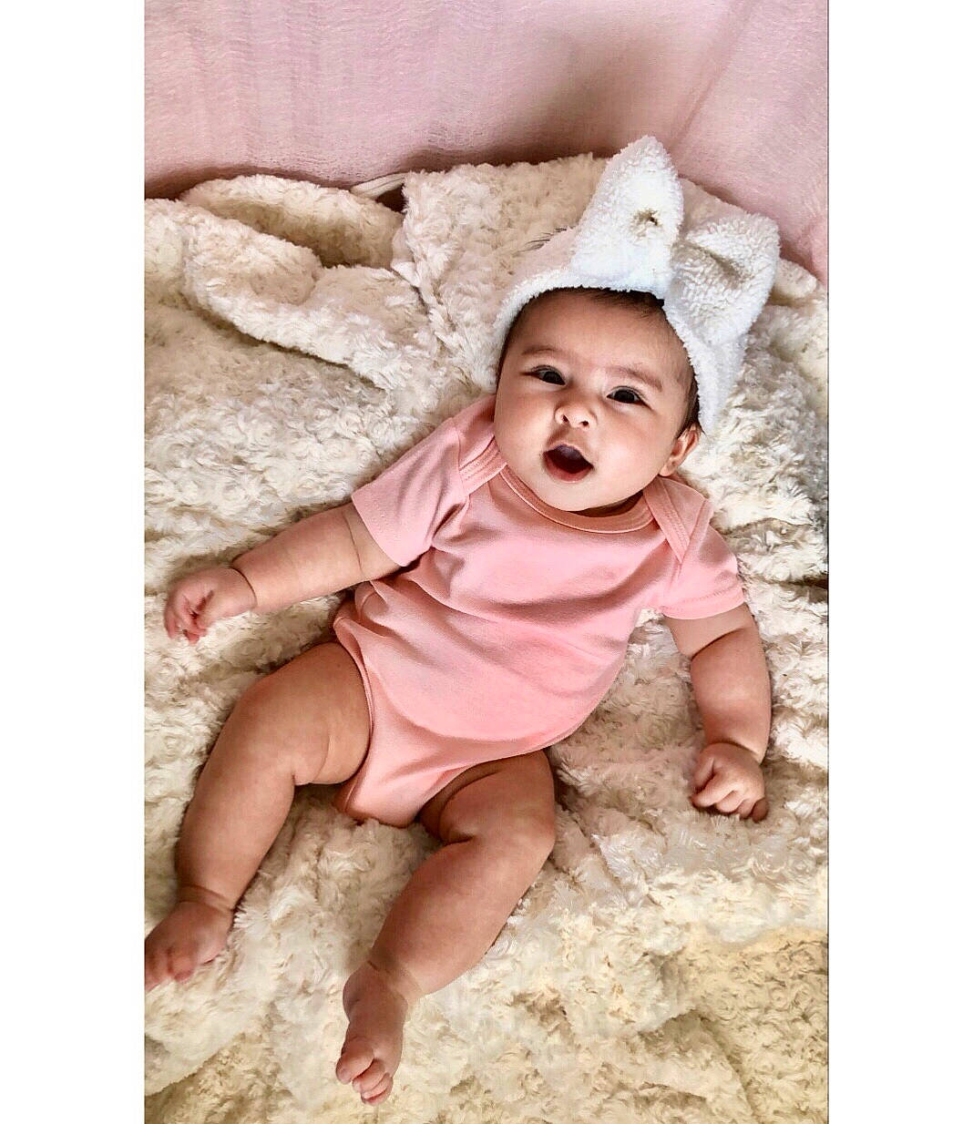 Arya is registered to the contest to win money with this photo: baby, baby_toddler_clothing, child, comfort, fashion_accessory, flesh, flooring, foot, happy, headwear, linens, magenta, pattern, person, portrait, portrait_photography, sitting, skin, sleeve, t_shirt