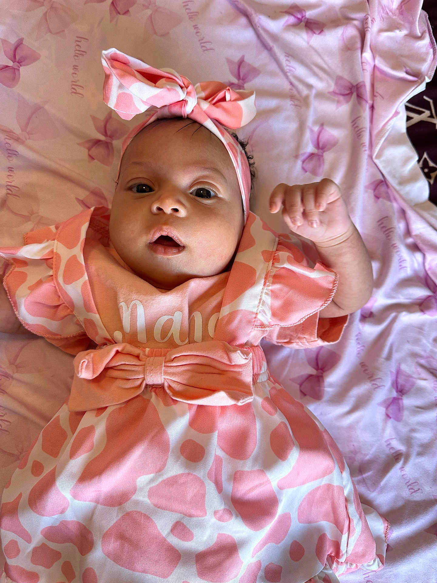 Zhanna is registered to the contest to win money with this photo: baby, blanket, bow, child, clothing, cute, dress, expression, face, happy, headband, indoor, infant, laying_down, newborn, pattern, person, pink, portrait, soft