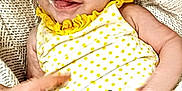 Sina is registered to the contest to win money with this photo: baby, bee, child, clothing, cozy, cute, expression, finger, hand, happy, infant, knitted_blanket, lying_down, person, polka_dot, portrait, skin, smile, texture, yellow