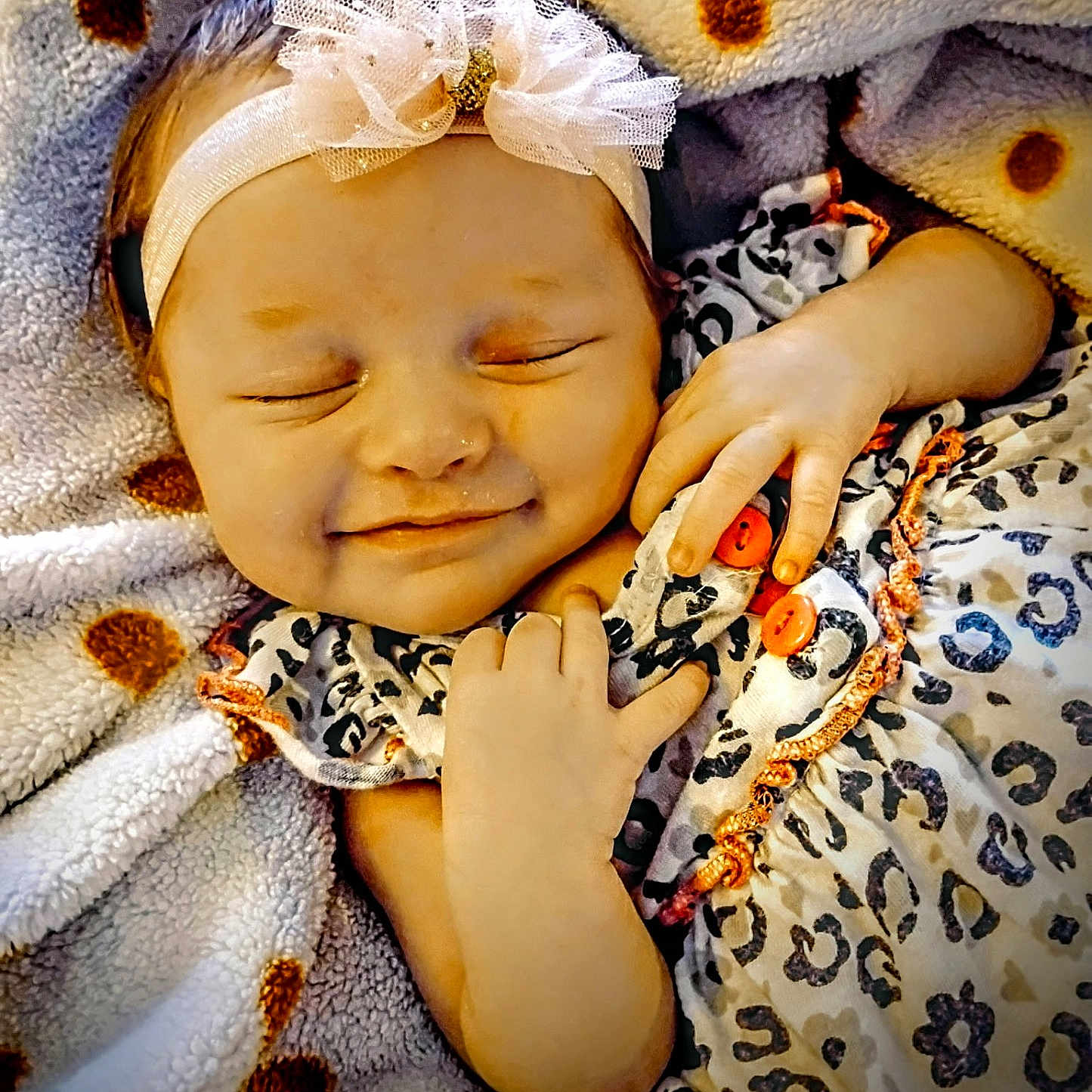 Sina is registered to the contest to win money with this photo: adorable, baby, blanket, bow, child, clothing, comfort, cozy, cute, face, hand, headband, infant, newborn, polka_dot, portrait, resting, sleeping, smiling, soft