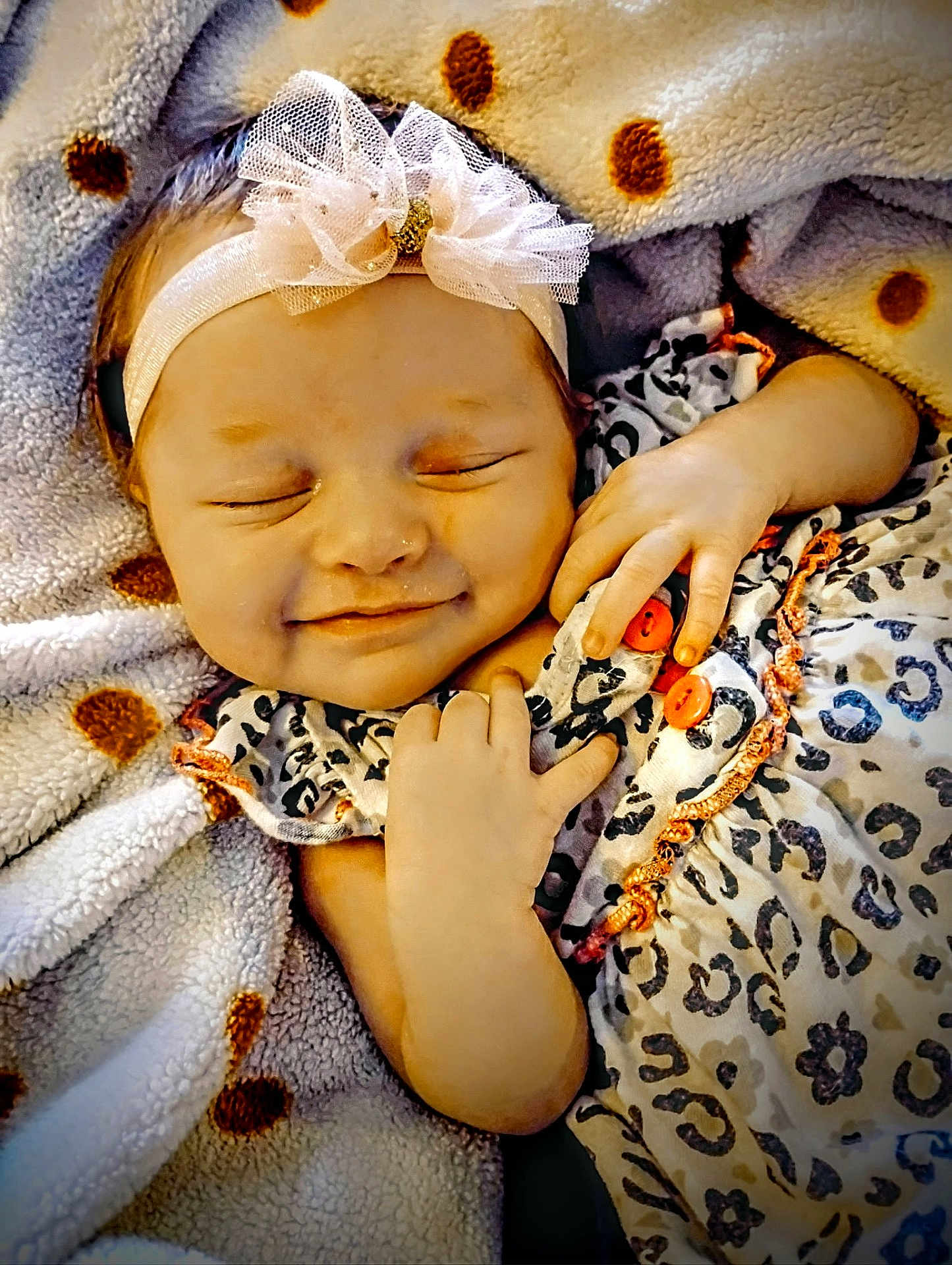 Sina is registered to the contest to win money with this photo: adorable, baby, blanket, bow, child, clothing, comfort, cozy, cute, face, hand, headband, infant, newborn, polka_dot, portrait, resting, sleeping, smiling, soft