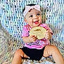 baby, black_shorts, blanket, bow, child, cute, hand, happy, indoor, infant, multicolor, person, pink_headband, pink_shirt, portrait, sitting, six_months_old, smiling, texture, wooden_plaque