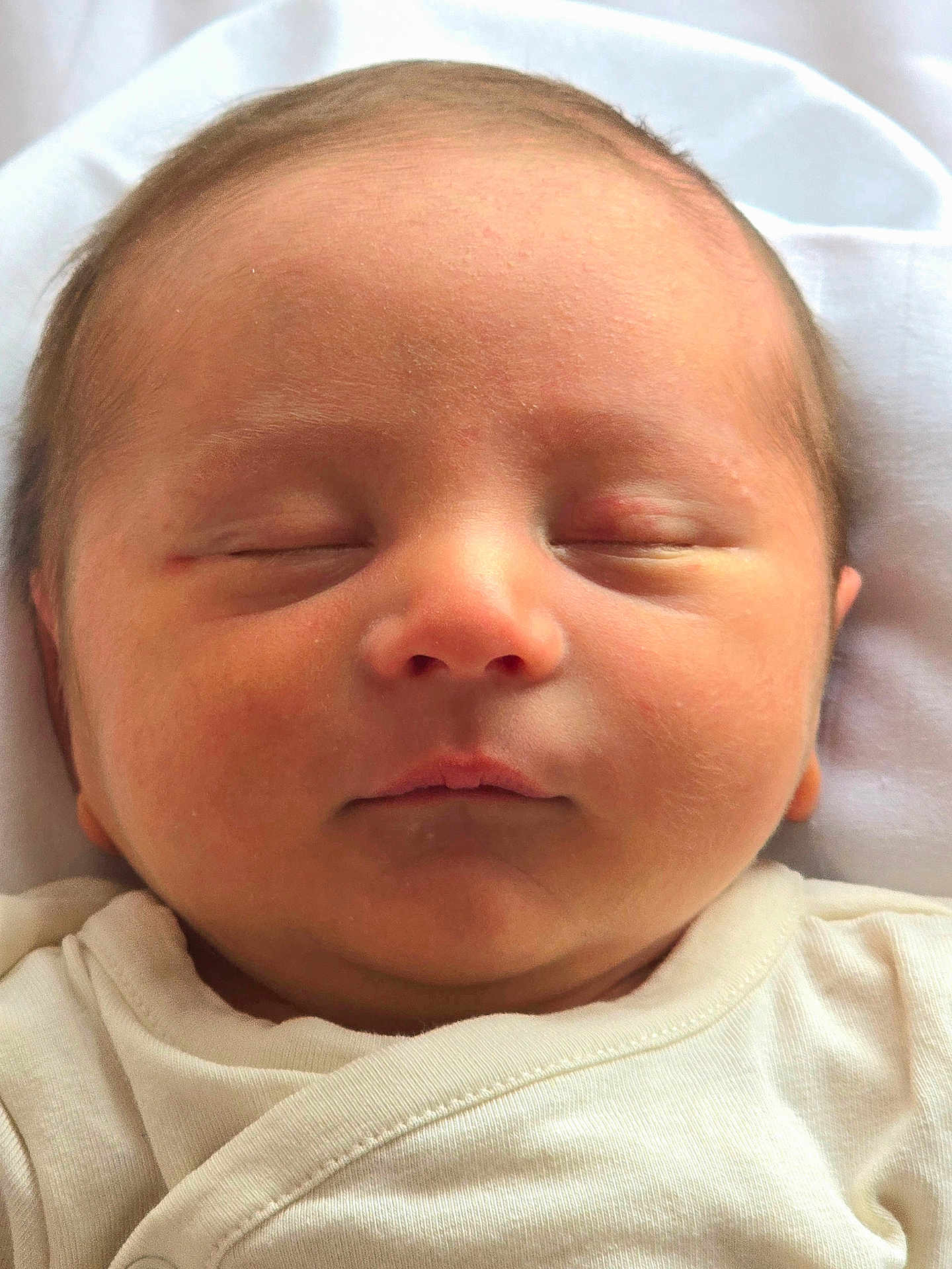 Benicio participe au concours pour gagner de l'argent avec cette photo : baby, newborn, infant, sleeping, closed_eyes, face, head, cheek, nose, lips, ear, chin, skin, onesie, white_clothing, pillow, bedding, portrait, close_up, peaceful